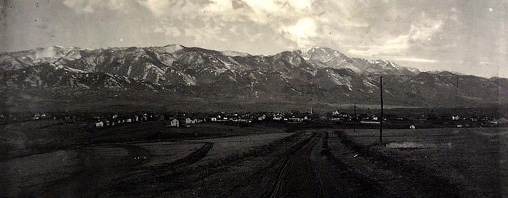 Early view of Colorado Springs from the prairie, with Pikes Peak and the Front Range behind the town
