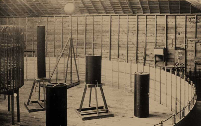 Interior of the Experimental Station, with the primary coil ringing the room and tall cylindrical coils on wooden stands